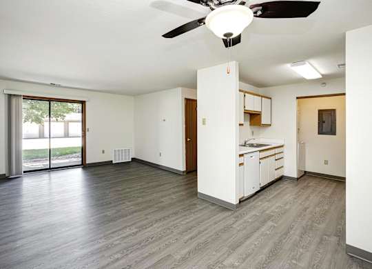 A room with a ceiling fan and a bed.