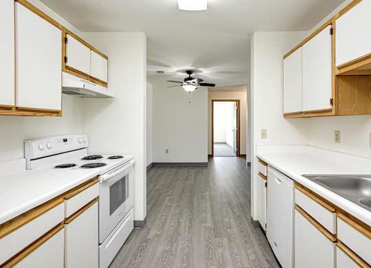 A kitchen with white cabinets and a wood trim.