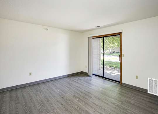 A room with a sliding glass door leading to a backyard.