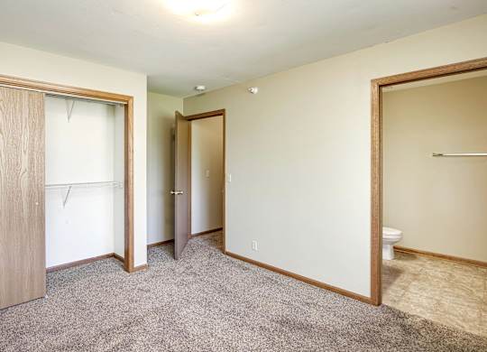A room with a carpeted floor and a toilet in the corner.