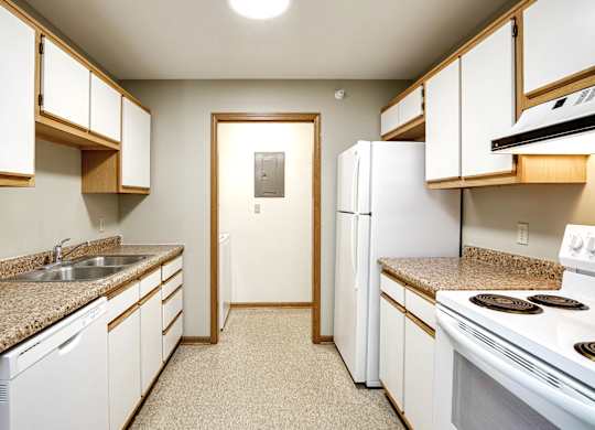 A kitchen with white appliances and wooden cabinets.
