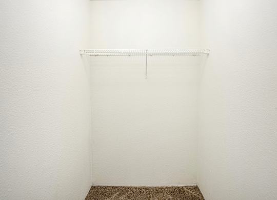 A white wall with a metal shelf on it.