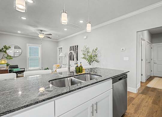 A modern kitchen with a granite countertop and stainless steel appliances.