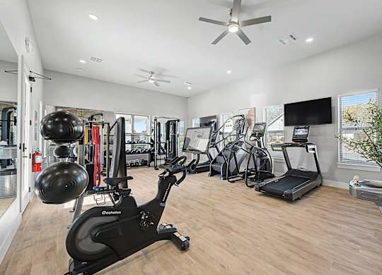 A spacious home gym with a variety of exercise equipment.