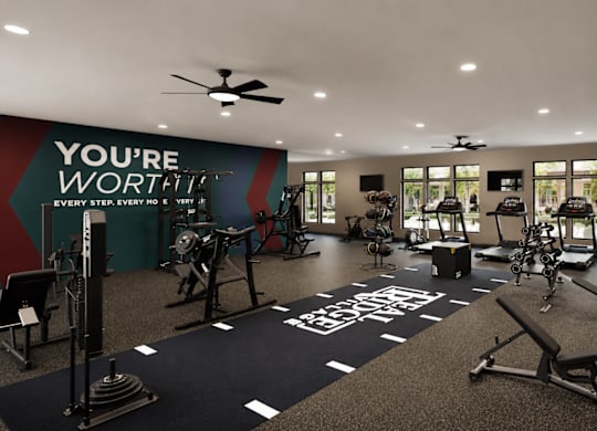 A gym with a variety of equipment and a motivational message on the wall.