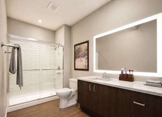 A modern bathroom with a toilet, sink, and shower.
