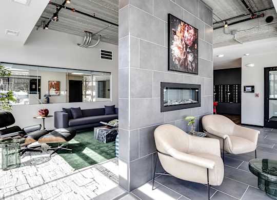 A modern waiting room with a large painting on the wall and comfortable seating.