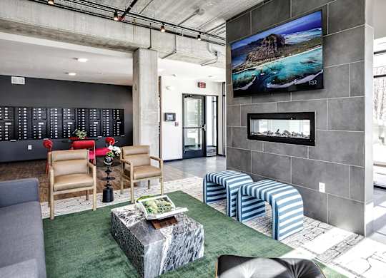 A modern living room with a large screen TV mounted on the wall.