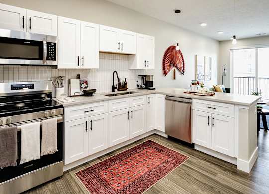 Brand new modern studio, one and two-bedroom apartment homes featuring stainless steel appliances, tile backsplash, quartz countertops, LVP flooring, large picture windows, in-unit washer and dryer and balconies at The Artisan at 39th in Omaha, NE