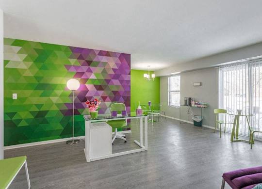 a room with a green and purple wall and a table and chairs