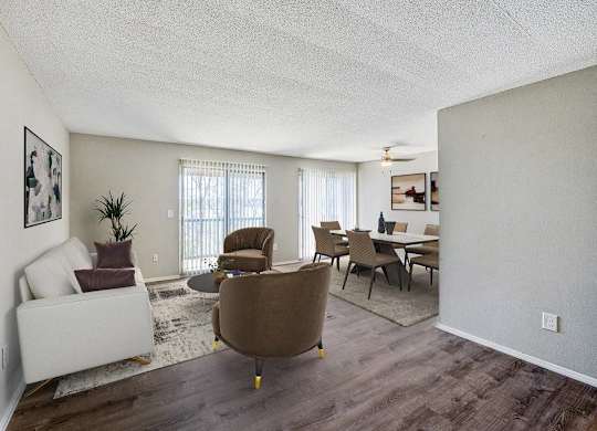 A living room with a brown chair and a white couch at The Waverly on the Lake - Belleville, MI Apartment, Belleville, MI, 48111