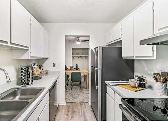 A kitchen with white cabinets and a black refrigerator at The Waverly on the Lake - Belleville, MI Apartment , Michigan