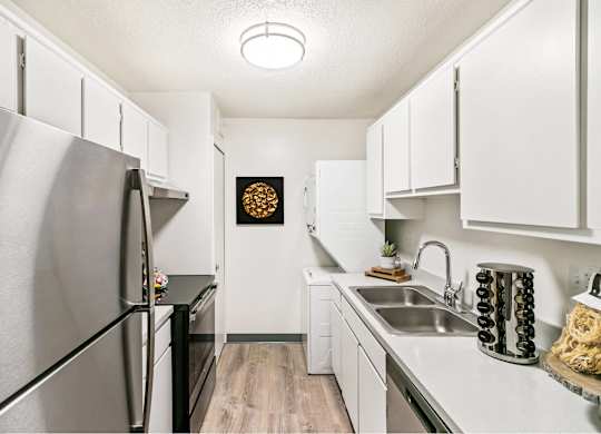 A kitchen with a stainless steel refrigerator and white cabinets at The Waverly on the Lake - Belleville, MI Apartment, Belleville, MI, 95050