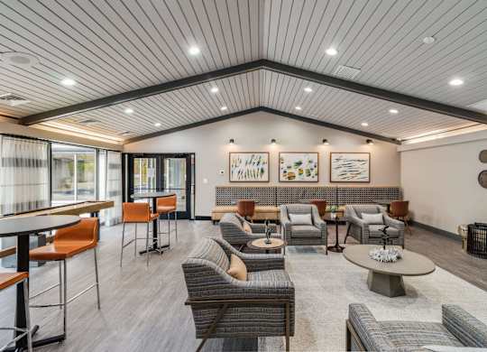 A spacious waiting area with a variety of seating options and artwork on the walls at The Waverly on the Lake - Belleville, MI Apartment , Michigan, 48111