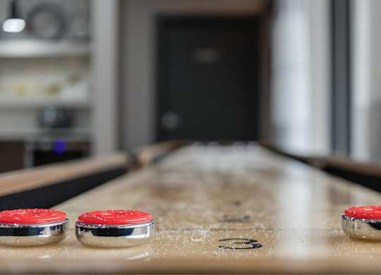 A table with two red buttons on it and a blurry background at The Waverly on the Lake - Belleville, MI Apartment , Belleville, 48111