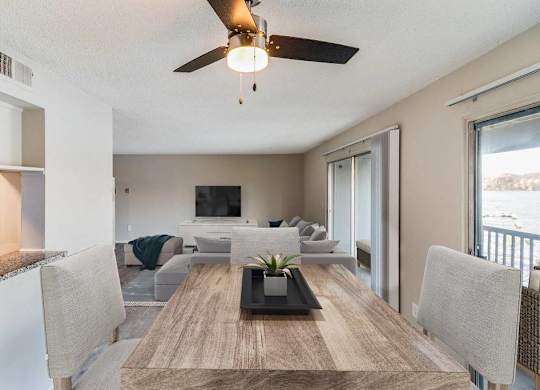 A modern dining room with a wooden table and grey chairs at The Waverly on the Lake - Belleville, MI Apartment , Belleville
