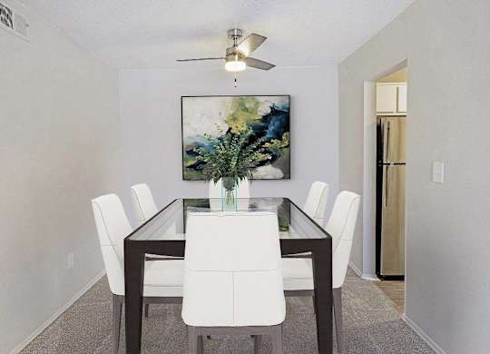 A dining room with a table and chairs and a painting on the wall at The Waverly on the Lake - Belleville, MI Apartment , Michigan, 48111