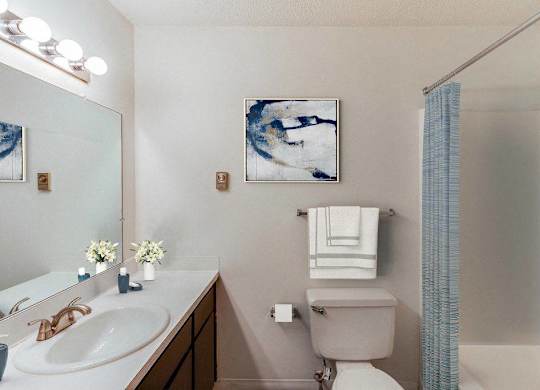 A bathroom with a toilet, sink, and shower at The Waverly on the Lake - Belleville, MI Apartment , Belleville, MI