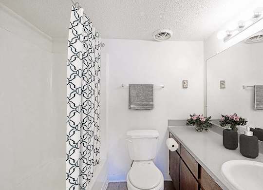A white toilet sits in a bathroom next to a sink at The Waverly on the Lake - Belleville, MI Apartment , Belleville, MI