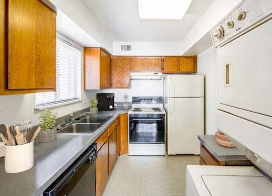 A kitchen with a white oven and black countertops at The Waverly on the Lake - Belleville, MI Apartment , Michigan, 95050