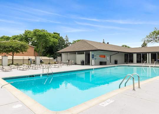 A large swimming pool with a building in the background at The Waverly on the Lake - Belleville, MI Apartment , Belleville, 95050