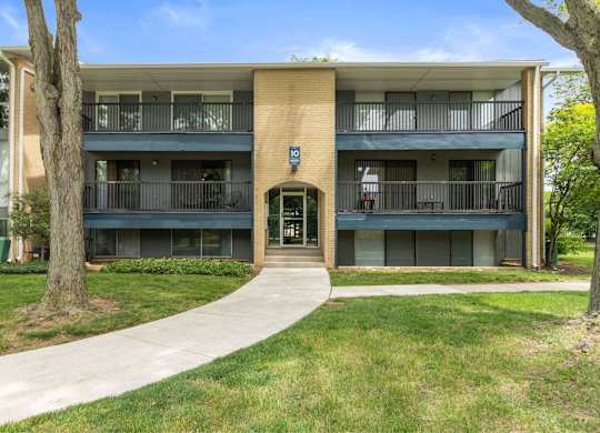 A building with a green door and windows on the side at The Waverly on the Lake - Belleville, MI Apartment , Belleville, MI