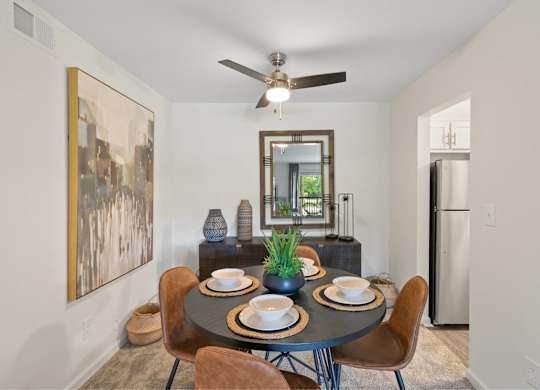 A dining room with a round table set for two at The Waverly on the Lake - Belleville, MI Apartment, Belleville, MI, 95050