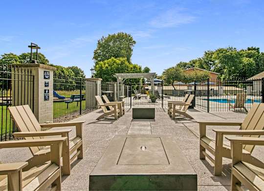 A sunny day at the park with wooden benches and a pool at The Waverly on the Lake - Belleville, MI Apartment , Michigan, 95050