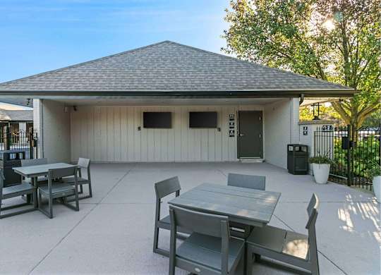 A patio with a table and chairs is set up outside a house at The Waverly on the Lake - Belleville, MI Apartment , Belleville, 95050