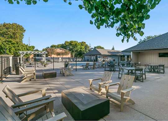 A sunny day at the park with wooden benches and picnic tables at The Waverly on the Lake - Belleville, MI Apartment , Belleville, 95050