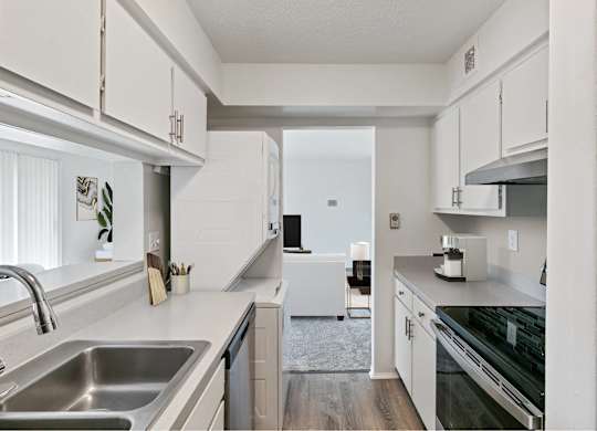 A modern kitchen with white cabinets and stainless steel appliances at The Waverly on the Lake - Belleville, MI Apartment , Michigan, 95050