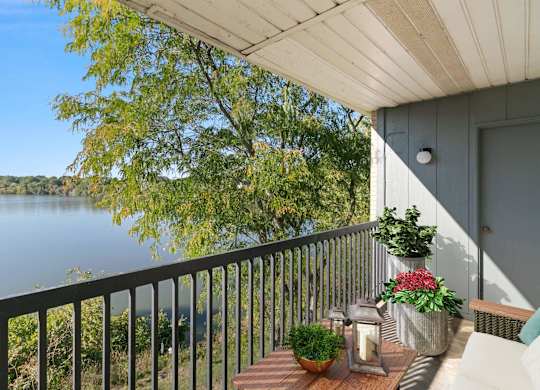 A balcony with a view of a lake and trees at The Waverly on the Lake - Belleville, MI Apartment , Belleville, 95050