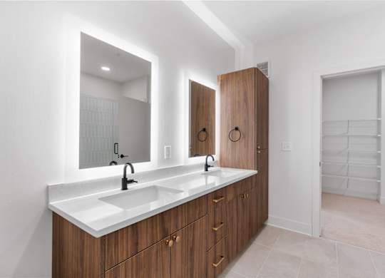 A bathroom with a double sink vanity and a large mirror.