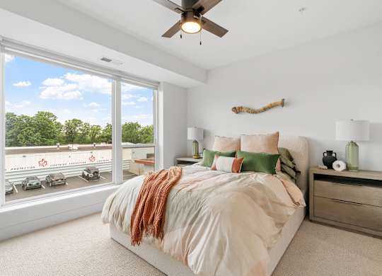 A bedroom with a queen-sized bed in a one-bedroom, one-bathroom apartment home at Lilia in Lilydale, MN 55118
