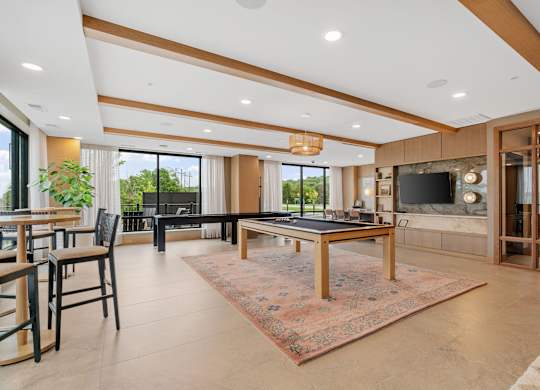 The billiards table and shuffleboard game in the Game Lounge, a reservable community room at Lilia in Lilydale, MN 55118