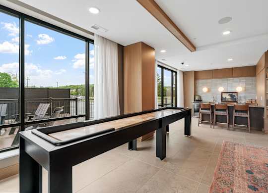 The billiards table and shuffleboard game in the Game Lounge, a reservable community room at Lilia in Lilydale, MN 55118