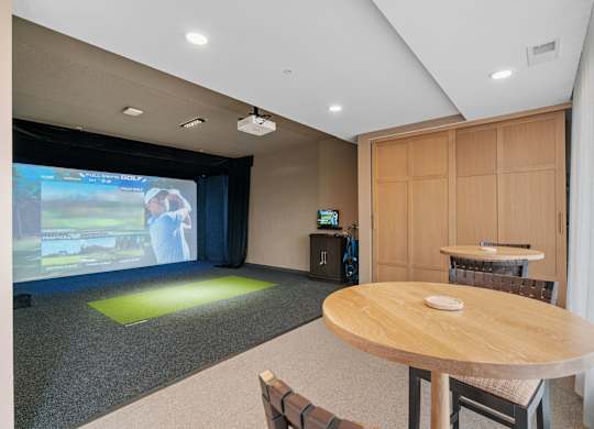 The Game and Golf Simulator with seating in the Game Lounge, a reservable community room at Lilia in Lilydale, MN 55118