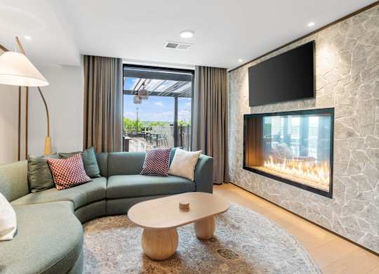 Comfortable seating across from the fireplace in the Clubroom, a reservable community room at Lilia in Lilydale, MN 55118