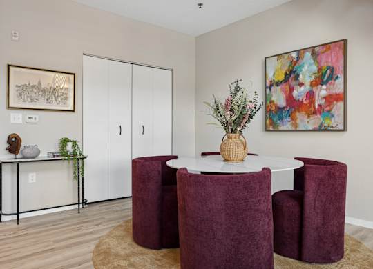 Dining room at The Ellory. A dining room with a white table and burgundy chairs.