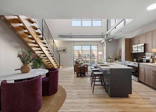 The Ellory Model Home. A modern kitchen with a dining table and chairs.