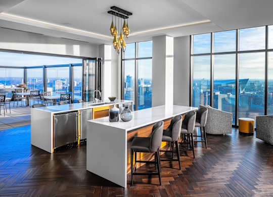 a dining room with a long white table and chairs and a view of the city at Expo, Minneapolis, MN