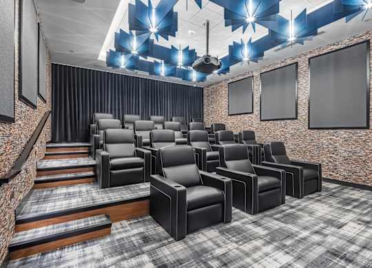 a theater room with chars and a projector screen on the ceiling at Expo, Minneapolis