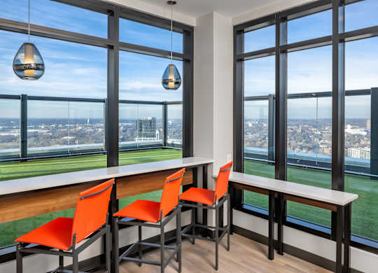 a dining room with a view of the city and a table with orange chairs at Expo, Minneapolis Minnesota