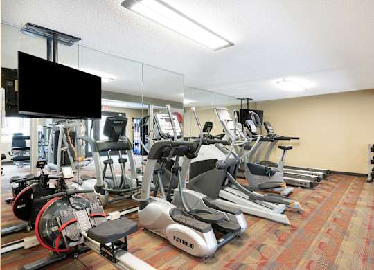 a room filled with cardio equipment and a flat screen tv at MacLaren Hill, St. Paul, MN, 55108