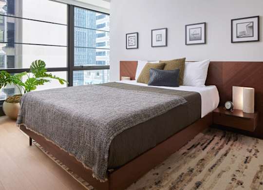 A bedroom with a large bed and a view of a city skyline. at 17 Market West, Pennsylvania