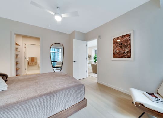 A bedroom with a bed, a chair, and a painting on the wall. at 17 Market West, Philadelphia, PA