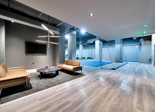 A modern living room with a wooden floor and a television on the wall.