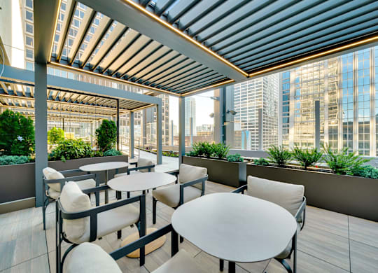 A patio with tables and chairs overlooking a cityscape. at 17 Market West, Philadelphia Pennsylvania