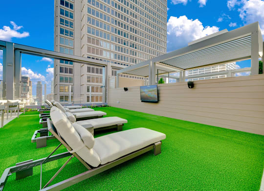 A rooftop patio with white lounge chairs and a green carpet. at 17 Market West, Philadelphia Pennsylvania