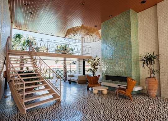 A wooden staircase with a glass railing leads to a balcony at The PARKER on E Mulberry Apartments, San Antonio, Texas